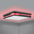 Na suficie lampa LED GENOVESE-Z emituje czerwone światło RGB wokół kwadratowej oprawy, tworząc barwną poświatę na jasnej powierzchni.