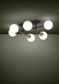 Na ciemnym tle lampa sufitowa PAZ rozświetla sześć białych kulistych kloszy rozmieszczonych wokół czarnej konstrukcji z mosiężnymi akcentami.