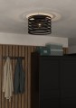 W nowoczesnym wnętrzu lampa sufitowa CREMELLA wyróżnia się czarnym ażurowym kloszem z poziomych metalowych pasów.