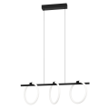 Lampa wisząca LED CARANACOA 3x9W z trzema okrągłymi elementami świetlnymi zawieszonymi na przewodach pod czarną podsufitką.