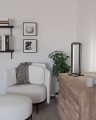 W jasnym salonie lampa stołowa LED SIBERIA stoi na komodzie, a jej czarna geometryczna forma kontrastuje z jasnym wystrojem wnętrza.