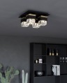 W nowoczesnym wnętrzu lampa sufitowa BARRANCAS rozświetla cztery kryształowe klosze, podkreślając czarno-złote wykończenie oprawy.