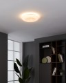 W nowoczesnym wnętrzu lampa sufitowa LED NIEVES 1 rozświetla okrągły dekoracyjny klosz, tworząc ciepłą poświatę na suficie.