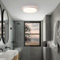 Okrągła lampa sufitowa LED FRANIA-S 15W zamontowana w łazience, emitująca ciepłe białe światło 3000K.