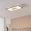 Kwadratowa lampa sufitowa LED MARMORATA z czarną obudową i dwiema strefami światła, zamontowana na suficie w jasnej sypialni.