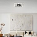 Lampa sufitowa LED ULISANO 21W z czarną geometryczną konstrukcją i przecinającymi się liniami światła, zamontowana w jasnym wnętrzu.