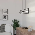 Lampa wisząca LED SIBERIA 34W o podłużnej czarnej konstrukcji, zawieszona w nowoczesnym wnętrzu nad komodą i roślinami.
