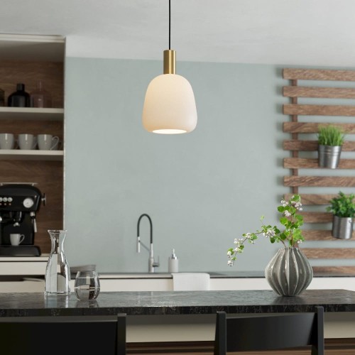 Lampa wisząca MANZANARES z białym szklanym kloszem i detalami w kolorze szczotkowanego mosiądzu, zawieszona nad blatem w kuchni.