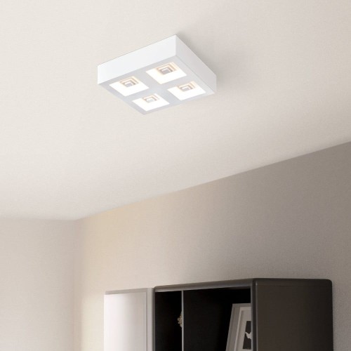 Kwadratowa lampa sufitowa LED FERREROS 4x6,3W zamontowana na suficie w jasnym wnętrzu, emitująca ciepłe białe światło 3000K.