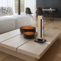 Drewniana lampa stołowa LED CAMACHO 6,5W ustawiona na stoliku, z pionowym elementem świetlnym i czarną prostokątną podstawą.