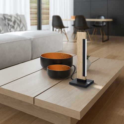 Drewniana lampa stołowa LED CAMACHO 6,5W ustawiona na stoliku, z pionowym elementem świetlnym i czarną prostokątną podstawą.