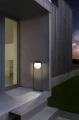 Przy ścieżce obok budynku lampa ogrodowa PRATA VECCHIA tworzy punkt światła, podkreślając smukłą pionową formę oprawy.