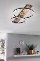 W nowoczesnym wnętrzu lampa sufitowa LED BOYAL tworzy dekoracyjną kompozycję dwóch świetlnych pierścieni wokół drewnianego elementu.