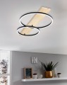 We wnętrzu lampa sufitowa LED BOYAL łączy dekor drewna z dwoma świetlnymi okręgami, tworząc nowoczesny akcent nad strefą mieszkalną.