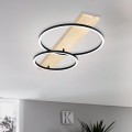 Lampa sufitowa LED BOYAL z drewnianą listwą i dwoma przecinającymi się ringami świetlnymi, zamontowana na suficie i świecąca ciepłą bielą 3000K.