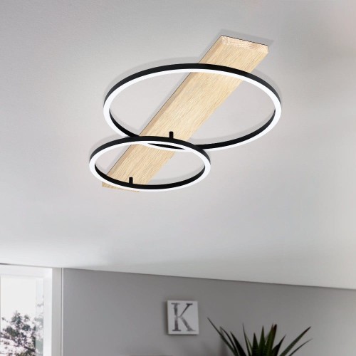 Lampa sufitowa LED BOYAL z drewnianą listwą i dwoma przecinającymi się ringami świetlnymi, zamontowana na suficie i świecąca ciepłą bielą 3000K.