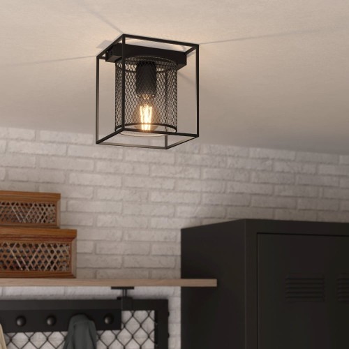 Czarna lampa sufitowa CATTERICK z pojedynczym cylindrycznym kloszem w metalowej ramie, zamontowana w nowoczesnym wnętrzu.