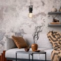 Lampa wisząca CALARI z czarną metalową oprawą, zawieszona nad stolikiem w industrialnym wnętrzu z ceglaną ścianą.