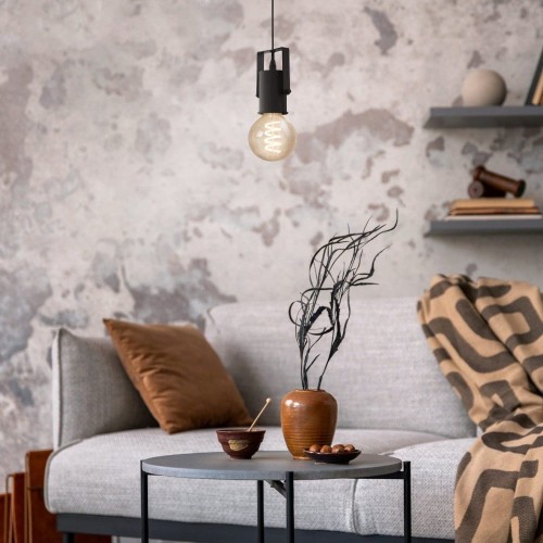 Lampa wisząca CALARI z czarną metalową oprawą, zawieszona nad stolikiem w industrialnym wnętrzu z ceglaną ścianą.