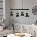 Lampa wisząca SHIREBROOK z czarną metalową konstrukcją i czterema kloszami, zawieszona nad stołem w jasnym wnętrzu.