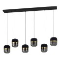 Lampa wisząca SINSIGA z sześcioma kloszami z tkaniny i szkła, zawieszonymi na czarnych przewodach pod podłużną podsufitką.
