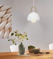 Nad stołem lampa wisząca CALMANERA tworzy subtelny akcent dzięki białemu kloszowi i dekoracyjnemu detalowi w kolorze mosiądzu.
