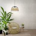 Lampa wisząca ANWICK z ażurowym kloszem z naturalnego rattanu i czarnego metalu, zawieszona w jasnym wnętrzu z roślinami doniczkowymi.