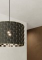 Zbliżenie klosza lampy MARASALES ukazuje czarną tkaninę z regularnym geometrycznym wzorem w kolorze mosiądzu oraz cylindryczną formę abażuru.