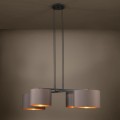 Lampa wisząca HONDURAS z trzema cylindrycznymi kloszami z tkaniny w kolorze cappuccino, zawieszona w ciemnym wnętrzu i emitująca ciepłe światło.