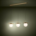 Lampa wisząca ARENALES z trzema białymi szklanymi kloszami, zawieszona na smukłych przewodach i emitująca ciepłe światło.