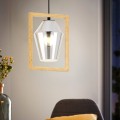 Lampa wisząca VIGLIONI z pojedynczym transparentnym szklanym kloszem w geometrycznej drewnianej ramie, zawieszona w jasnym wnętrzu i emitująca ciepłe światło.