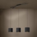 Lampa wisząca BALNARIO z trzema czarnymi cylindrycznymi kloszami z tkaniny, zawieszona w nowoczesnym wnętrzu i emitująca światło na ścianę.