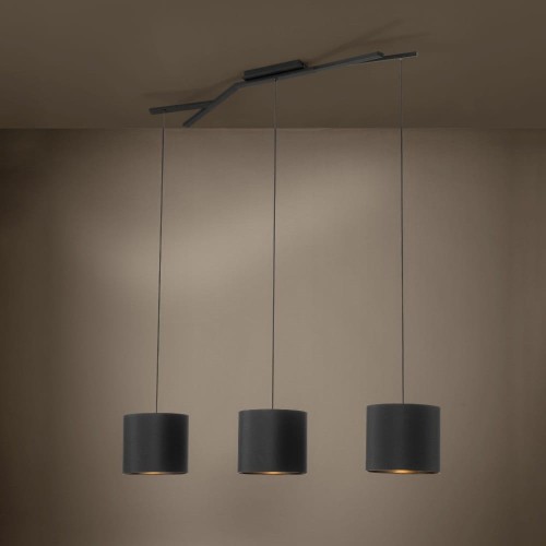 Lampa wisząca BALNARIO z trzema czarnymi cylindrycznymi kloszami z tkaniny, zawieszona w nowoczesnym wnętrzu i emitująca światło na ścianę.