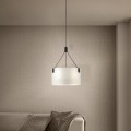 Lampa wisząca TORTOLA z białym tekstylnym kloszem i czarnymi elementami zawieszenia, zamontowana w przytulnym salonie nad stolikiem.