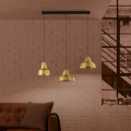 Lampa wisząca SAVARNA z trzema złotymi metalowymi kloszami o stożkowym kształcie, zawieszona na czarnych przewodach w nowoczesnym wnętrzu.