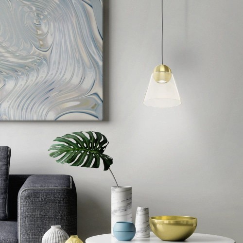 Lampa wisząca CERASELLA z pojedynczym transparentnym szklanym kloszem i mosiężnymi detalami, zawieszona nad stolikiem w jasnym wnętrzu.