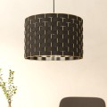Lampa wisząca MARASALES z czarnym cylindrycznym kloszem z tkaniny, ozdobionym geometrycznym wzorem w kolorze mosiądzu, zawieszona w jasnym wnętrzu.