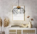 Lampa wisząca PADSTOW z szerokim ażurowym kloszem z czarnego metalu i drewnianym detalem w kolorze brązowym, zawieszona nad stołem.