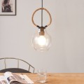 Lampa wisząca RODING z przezroczystym szklanym kloszem i dekoracyjnym pierścieniem z liny konopnej, zawieszona w jasnym wnętrzu.