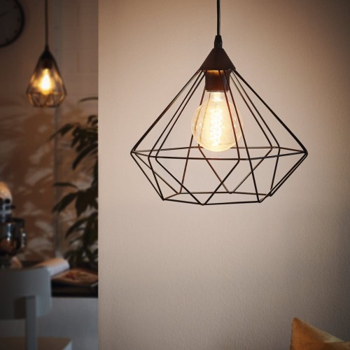 Lampa wisząca TARBES z czarnym metalowym kloszem o geometrycznej, ażurowej konstrukcji, zawieszona w nowoczesnym wnętrzu z widoczną żarówką E27.