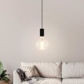 Lampa wisząca POZUETA z czarną metalową oprawką i odsłoniętą żarówką E27, zawieszona na długim przewodzie w jasnym salonie.