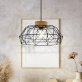 Lampa wisząca PADSTOW z czarnym metalowym kloszem o ażurowej konstrukcji i brązowym drewnianym elementem, zawieszona w jasnym wnętrzu.