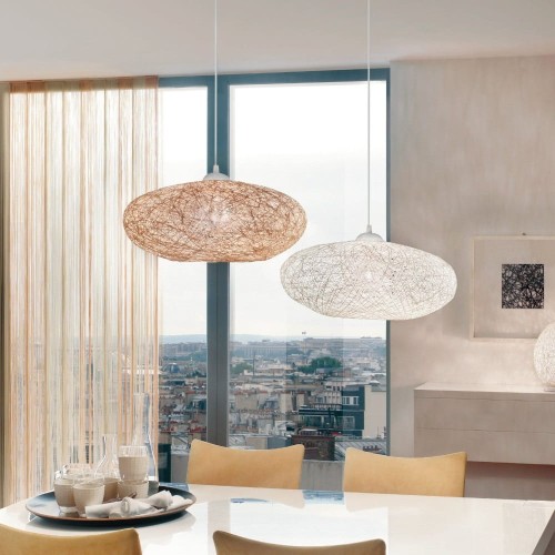 Lampa wisząca CAMPILO z szerokim, spłaszczonym kloszem wykonanym z białych papierowych nici, zawieszona nad stołem w jasnym wnętrzu.