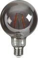 Nowoczesne lampy wiszące z dekoracyjnymi żarówkami LED w metalowych oprawach na tle jasnej ściany z rośliną pnącą.