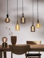 Zestaw wiszących lamp z dekoracyjnymi żarówkami LED filament o różnych kształtach nad drewnianym stołem w aranżacji wnętrza.