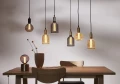 Zestaw wiszących lamp z dekoracyjnymi żarówkami LED filament nad drewnianym stołem i krzesłem w nowoczesnej aranżacji wnętrza.