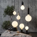 Zestaw dekoracyjnych żarówek LED kulistych w różnych rozmiarach, nowoczesna aranżacja wnętrza z przytulnym klimatem.