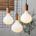 Trzy wiszące lampy z dużymi żarówkami LED matowymi w drewnianych oprawkach, ciepłe światło w nowoczesnym wnętrzu.