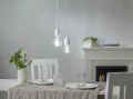 Wiszące lampy z żarówkami LED E27 o chłodniejszej barwie światła nad stołem z nakryciem, jasna aranżacja wnętrza.