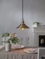 Lampa wisząca z metalowym kloszem i żarówką LED filament E27 nad stołem, ciepłe światło w przytulnym wnętrzu.